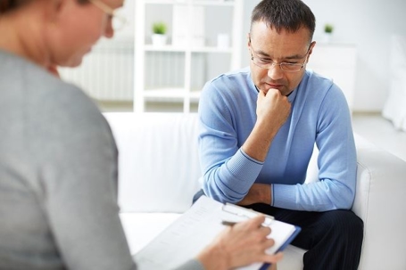 Man thinking in front of a woman checking a document.